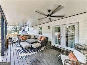 wooden deck featuring french doors, outdoor lounge area, and ceiling fan