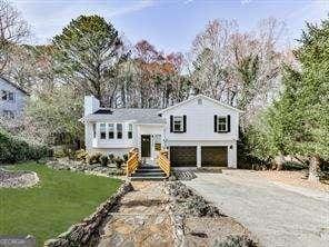 view of front of home featuring aphalt driveway, a front yard, and a garage