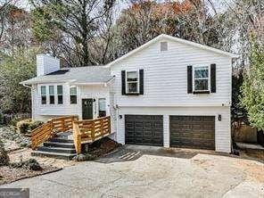 view of front of property with aphalt driveway, a chimney, and an attached garage