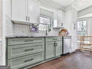 bar featuring a sink, backsplash, and stainless steel dishwasher