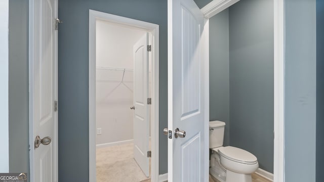 bathroom featuring toilet and baseboards