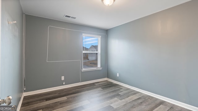 unfurnished room with visible vents, baseboards, and wood finished floors