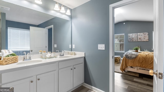 bathroom featuring a sink, wood finished floors, visible vents, and connected bathroom