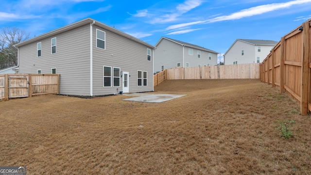 back of property with a yard, a patio, and a fenced backyard