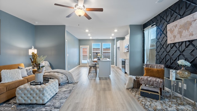 living area featuring recessed lighting, light wood-type flooring, baseboards, and ceiling fan