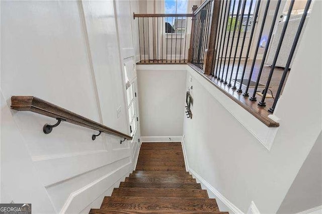 stairway with wood finished floors and baseboards