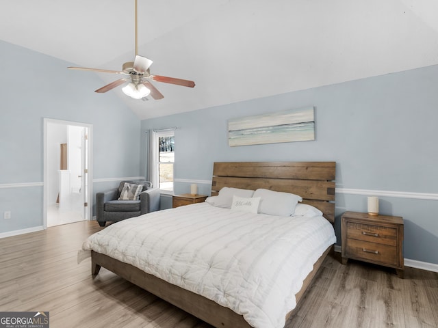 bedroom featuring connected bathroom, baseboards, wood finished floors, and a ceiling fan