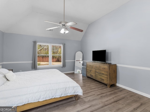 bedroom featuring visible vents, lofted ceiling, wood finished floors, baseboards, and ceiling fan