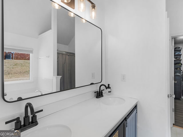 full bathroom with double vanity and a sink