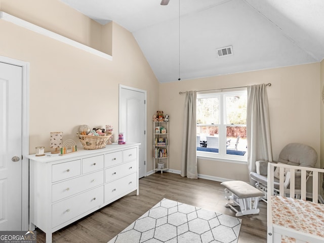 bedroom featuring visible vents, high vaulted ceiling, baseboards, and wood finished floors