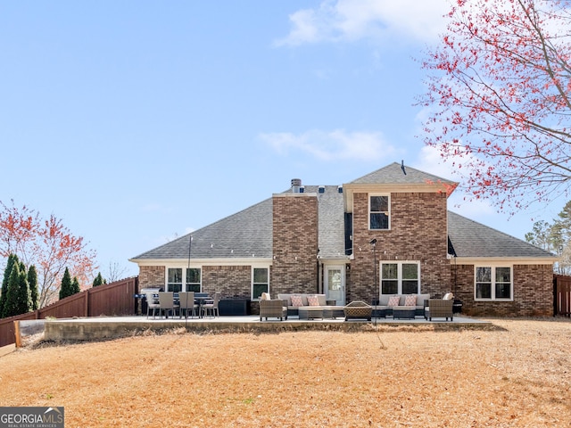 back of house featuring a patio, a fenced backyard, brick siding, and an outdoor hangout area