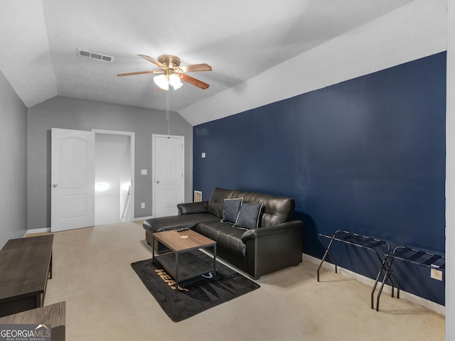 living room with a ceiling fan, visible vents, carpet floors, baseboards, and vaulted ceiling