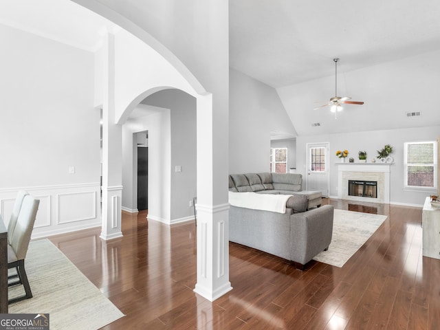 living room with visible vents, high vaulted ceiling, a ceiling fan, dark wood finished floors, and a high end fireplace