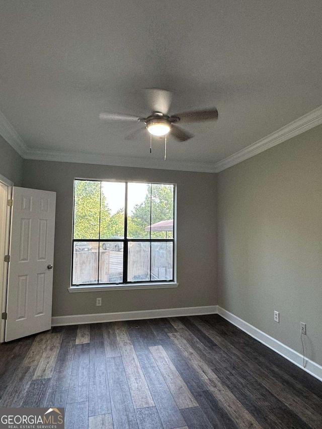 empty room with dark wood finished floors, a ceiling fan, baseboards, and ornamental molding