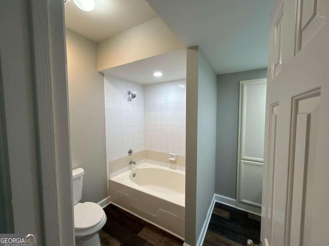 bathroom with toilet,  shower combination, baseboards, and wood finished floors