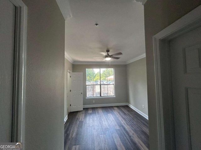 empty room with dark wood finished floors, a ceiling fan, baseboards, and ornamental molding