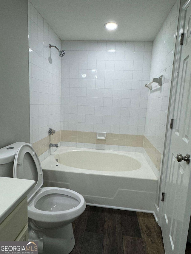 full bath featuring vanity, toilet, wood finished floors, and tub / shower combination