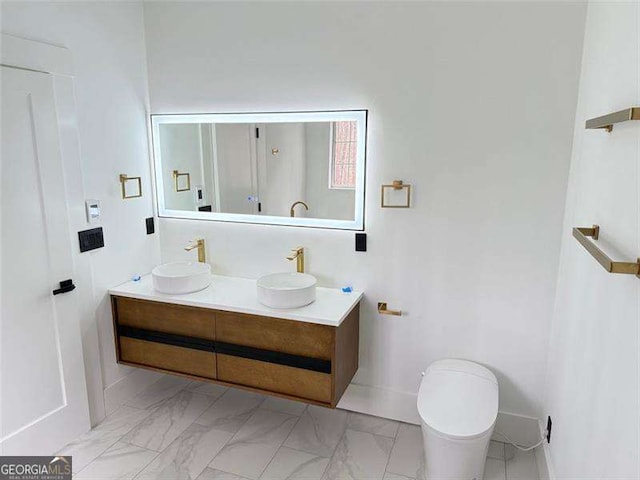 full bath with a sink, marble finish floor, and double vanity