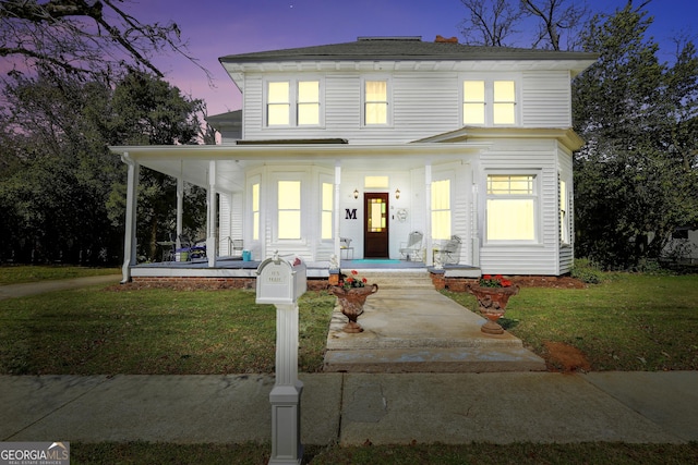 view of front of house with a yard and covered porch