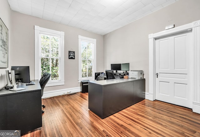 home office with baseboards and wood finished floors