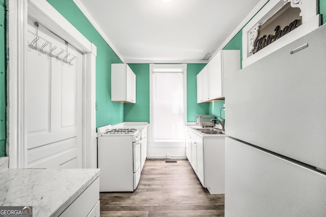 washroom with a sink, laundry area, and wood finished floors