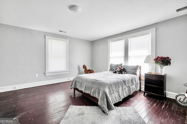 bedroom with visible vents, baseboards, and hardwood / wood-style floors