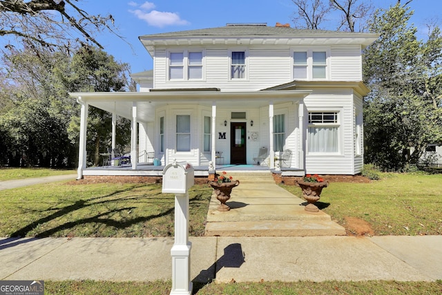 view of front of house with covered porch and a front yard