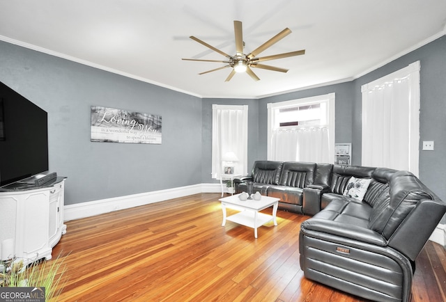 living room featuring light wood-style flooring, baseboards, ornamental molding, and a ceiling fan