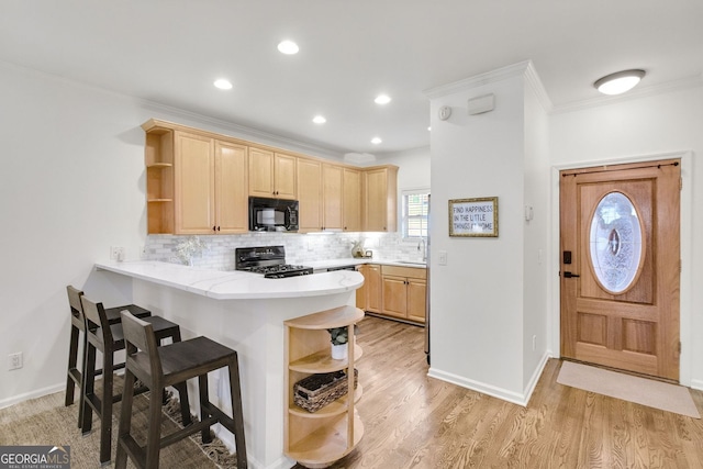 kitchen with light brown cabinets, gas range oven, black microwave, and open shelves