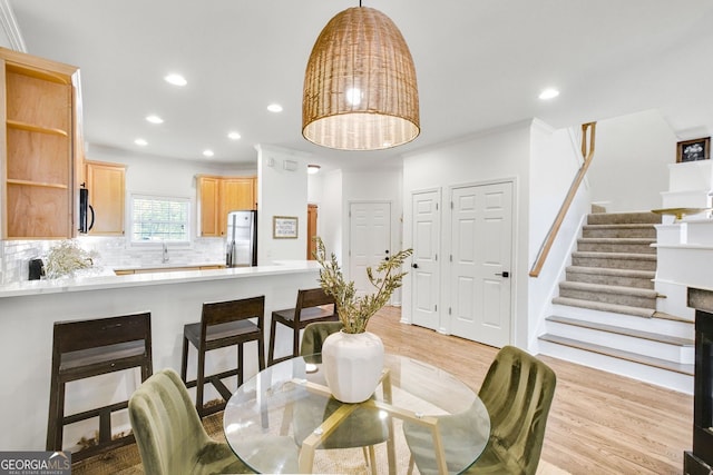 dining area with stairs, recessed lighting, light wood finished floors, and ornamental molding