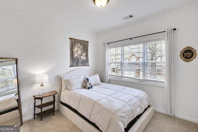 carpeted bedroom with visible vents, baseboards, and crown molding