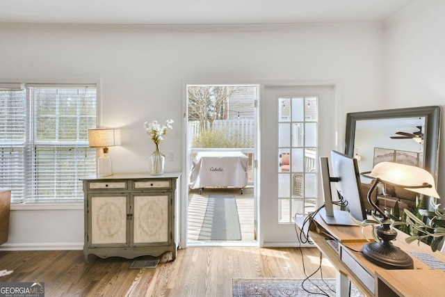 interior space featuring crown molding, baseboards, and wood finished floors