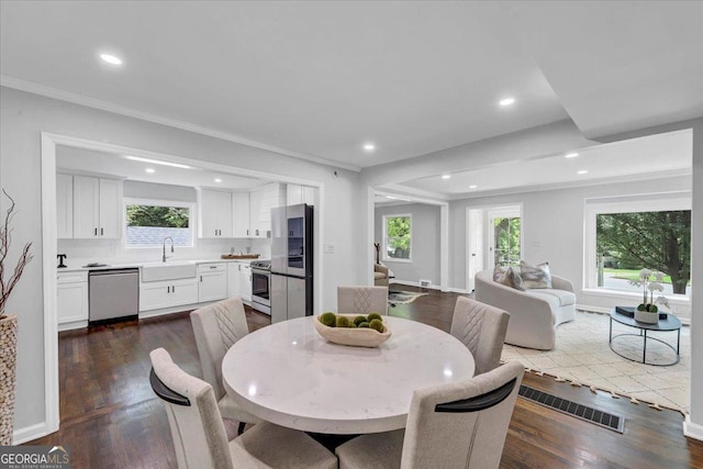 dining room featuring dark wood-style floors, visible vents, recessed lighting, and crown molding