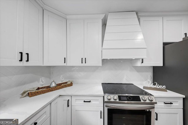 kitchen featuring stainless steel appliances, white cabinetry, light countertops, and custom range hood