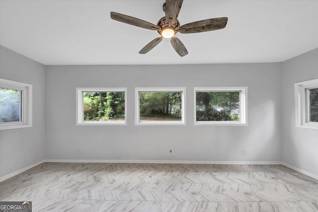 spare room with baseboards, a healthy amount of sunlight, and ceiling fan