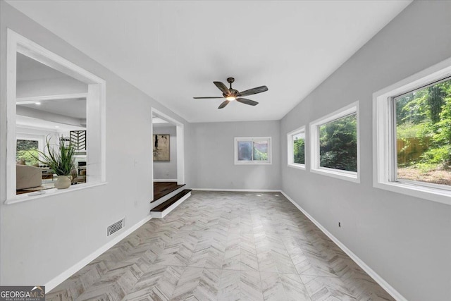 unfurnished room featuring visible vents, ceiling fan, and baseboards