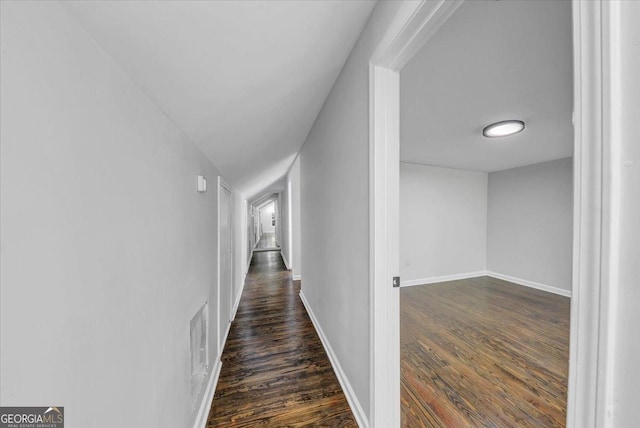 corridor with visible vents, baseboards, and dark wood finished floors