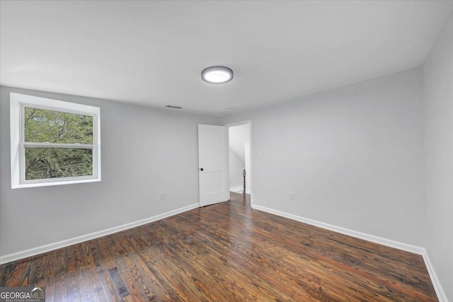 unfurnished room with visible vents, baseboards, and wood finished floors