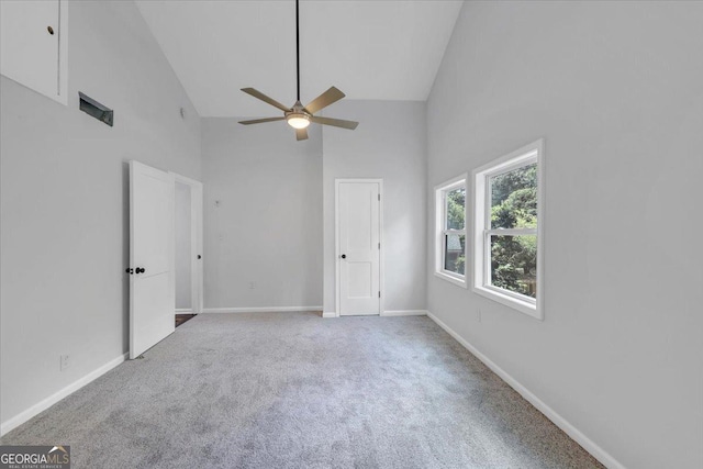 unfurnished bedroom featuring carpet flooring, baseboards, and high vaulted ceiling