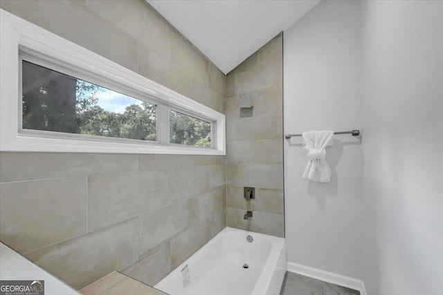 full bathroom with baseboards and vaulted ceiling