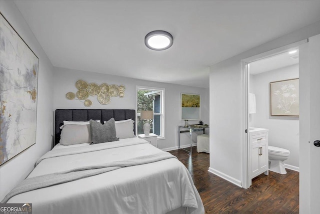 bedroom with baseboards, ensuite bath, and dark wood-style floors