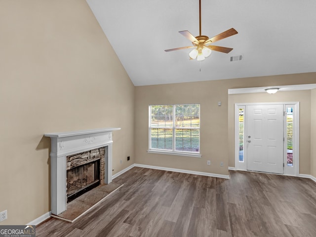 unfurnished living room with visible vents, a stone fireplace, baseboards, and wood finished floors