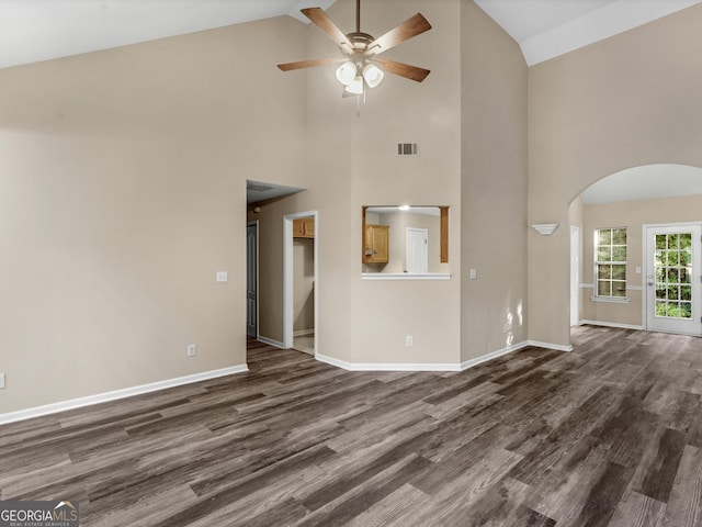 unfurnished living room featuring visible vents, arched walkways, baseboards, and dark wood-style flooring