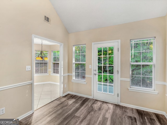 doorway to outside with visible vents, baseboards, lofted ceiling, and wood finished floors