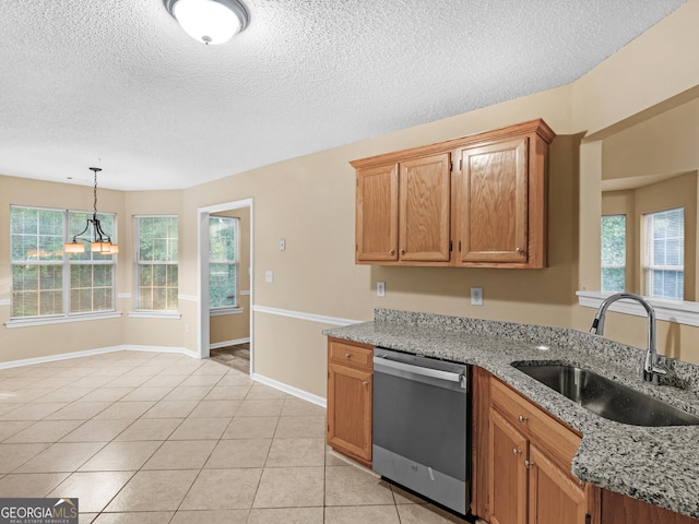 kitchen featuring dishwasher, light stone counters, light tile patterned floors, and a sink