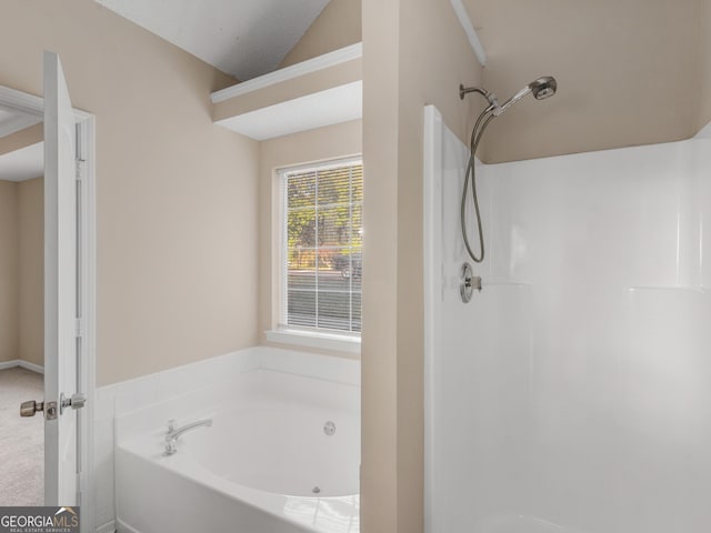 bathroom featuring lofted ceiling, a bath, and walk in shower