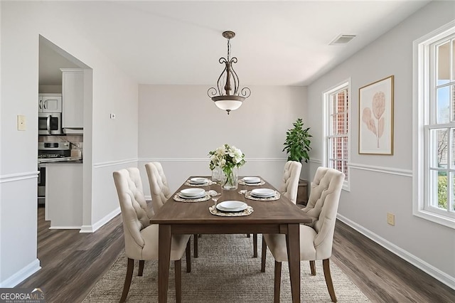 dining space featuring baseboards, dark wood finished floors, and visible vents