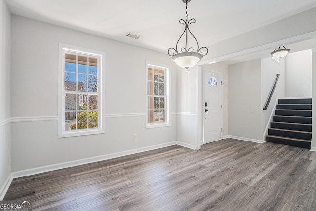 entrance foyer featuring stairway, baseboards, visible vents, and wood finished floors