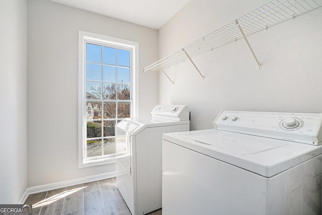 laundry room featuring light wood-type flooring, baseboards, separate washer and dryer, and laundry area