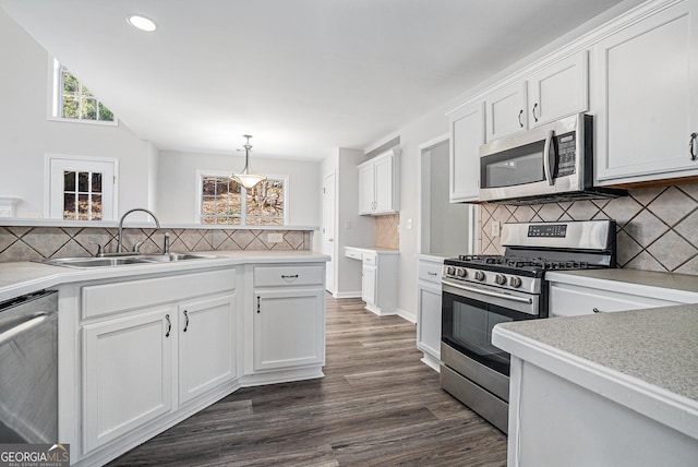 kitchen featuring a sink, stainless steel appliances, a healthy amount of sunlight, and white cabinetry